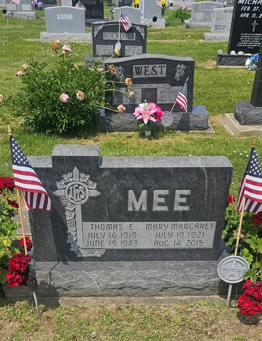 Mee family headstone with cross and floral tribute at a Logansport cemetery